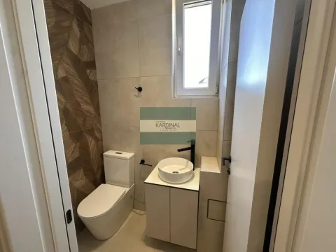 Manje kupatilo sa WC šoljom, umivaonikom i dekorativnim pločicama. - image 5