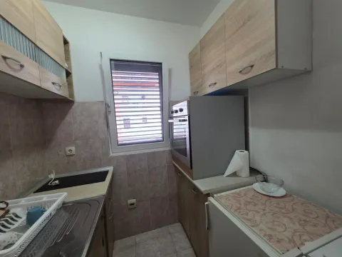 Small kitchen with wooden cabinets and built-in appliances. - image 10