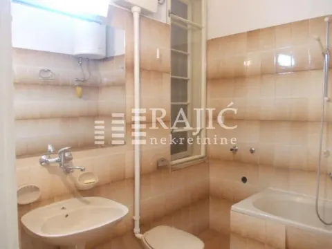 Smaller bathroom with a bathtub, washbasin, and toilet. - image 15