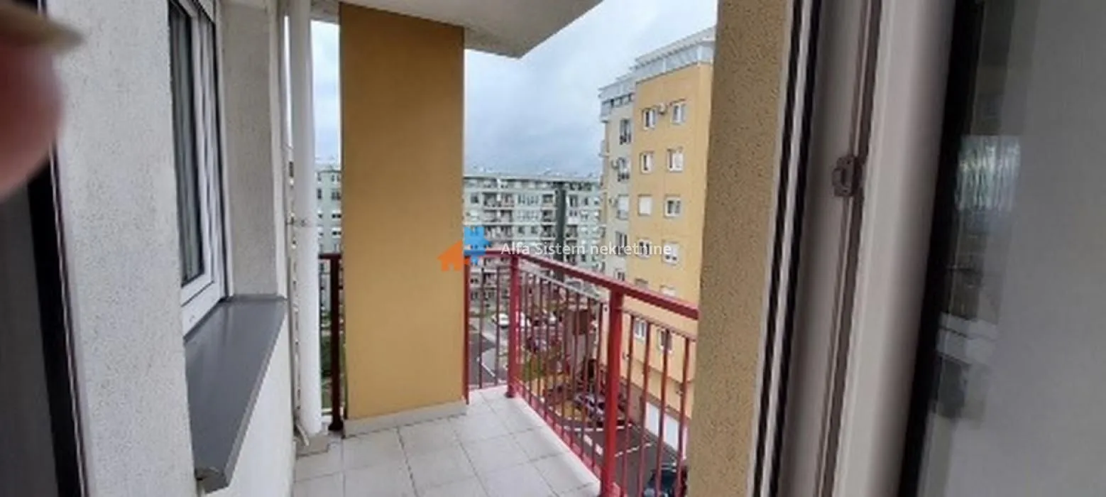 Pogled sa balkona na okolne zgrade i naselje.