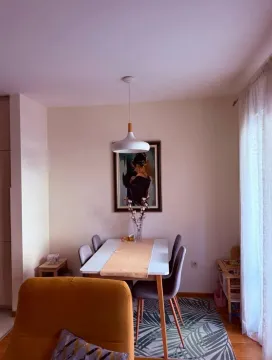Dining area with a table, chairs, and a pendant lamp as part of the living room. - image 4