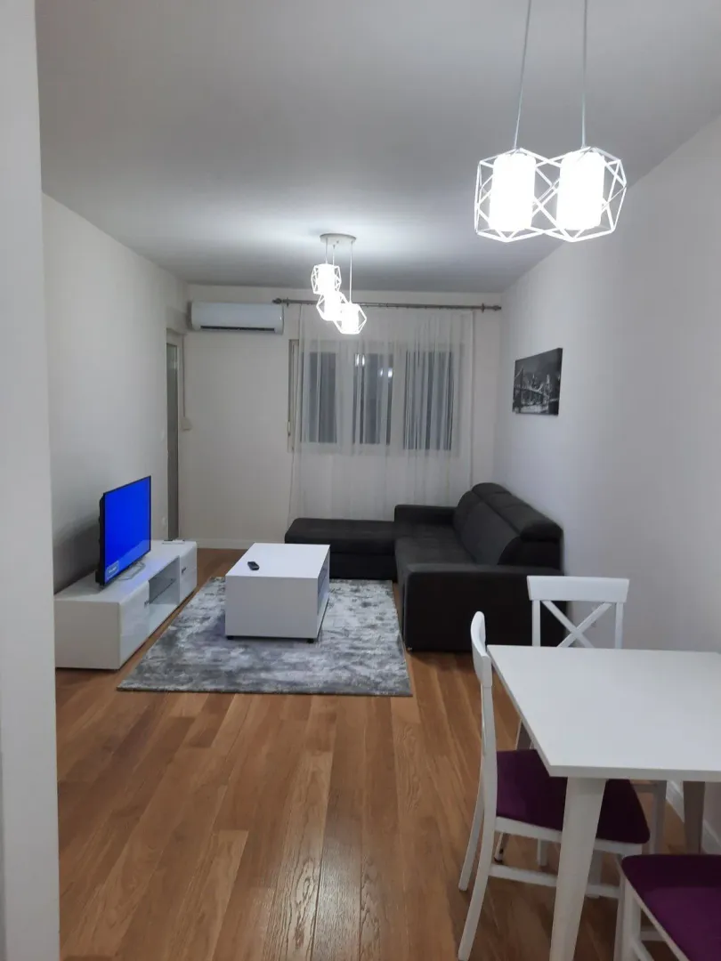 Bright living room with a corner sofa and a dining table.