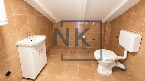Attic bathroom tiled with ceramic tiles featuring a sink and a toilet. - image 20