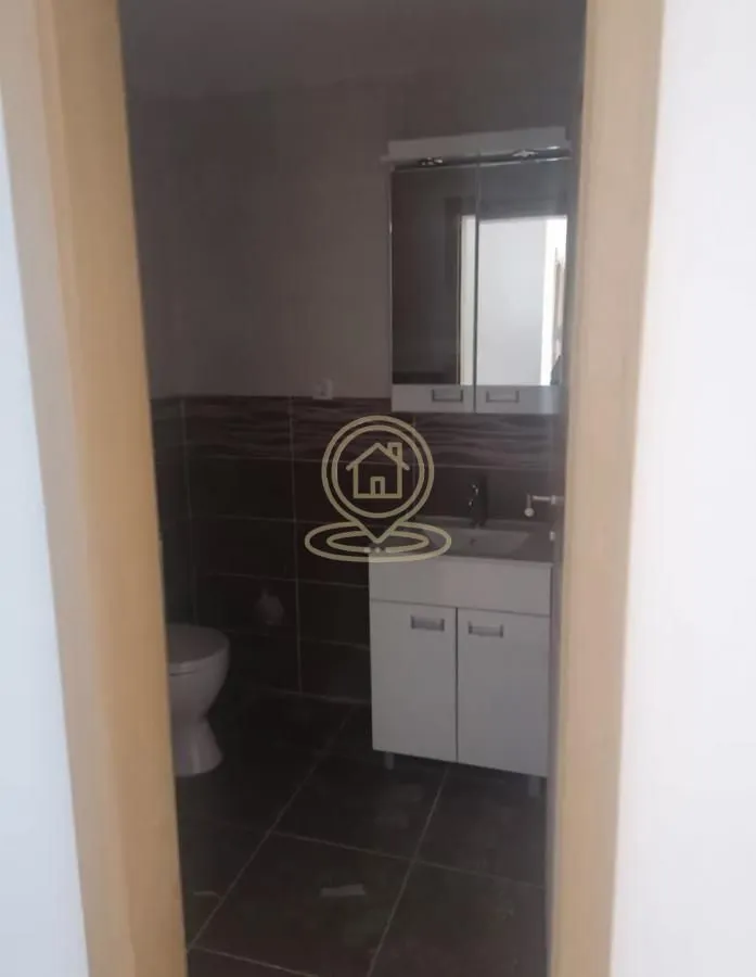 Pogled na kupatilo sa umivaonikom, ogledalom i toaletom.