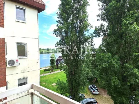 Pogled sa balkona na reku, zelenilo i okolne zgrade. - image 8