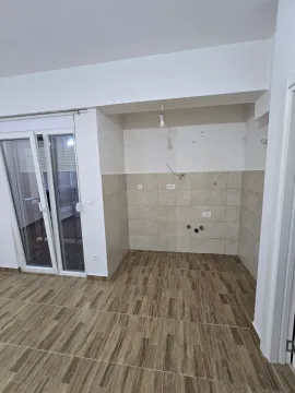 Empty kitchen space with ceramic tiles and terrace access. - image 3