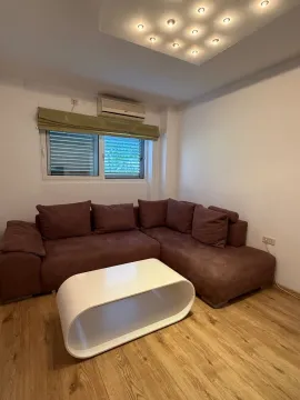 Living room with a sectional sofa and a white coffee table. - image 10