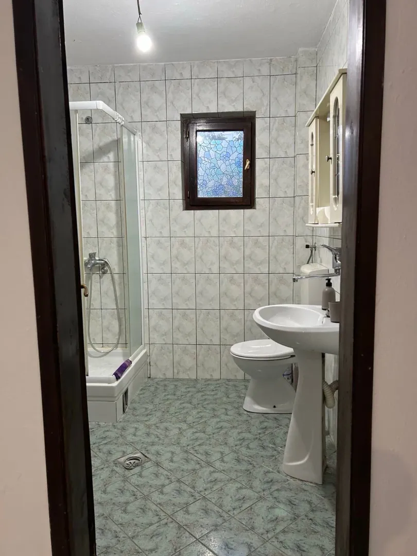 View of the bathroom with a shower cabin, washbasin, and toilet.