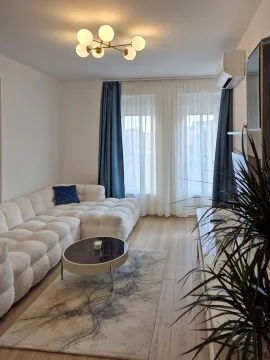 Dnevna soba sa udobnom ugaonom garniturom, klub stolićem i velikim prozorima. - image 3