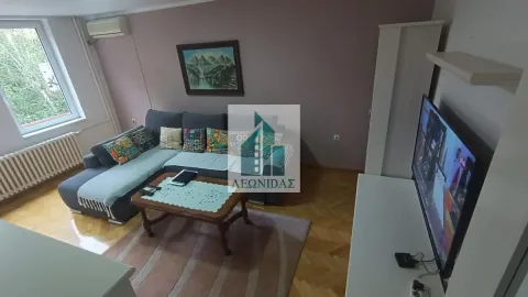 Living room with a sectional sofa, coffee table, and television. - image 4