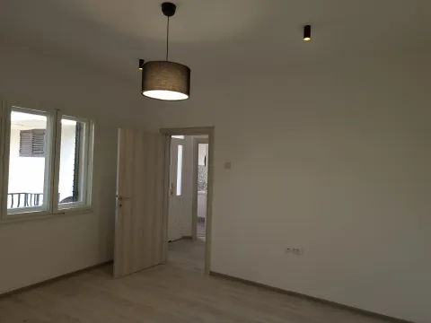 Empty room with white walls, a window, and an open door. - image 5