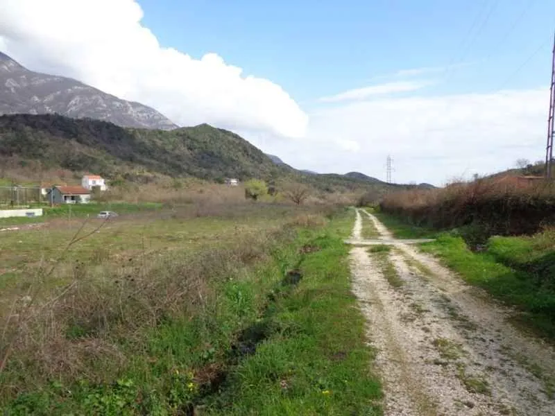 Pogled na zemljište i okolni pejzaž sa brdima u pozadini.