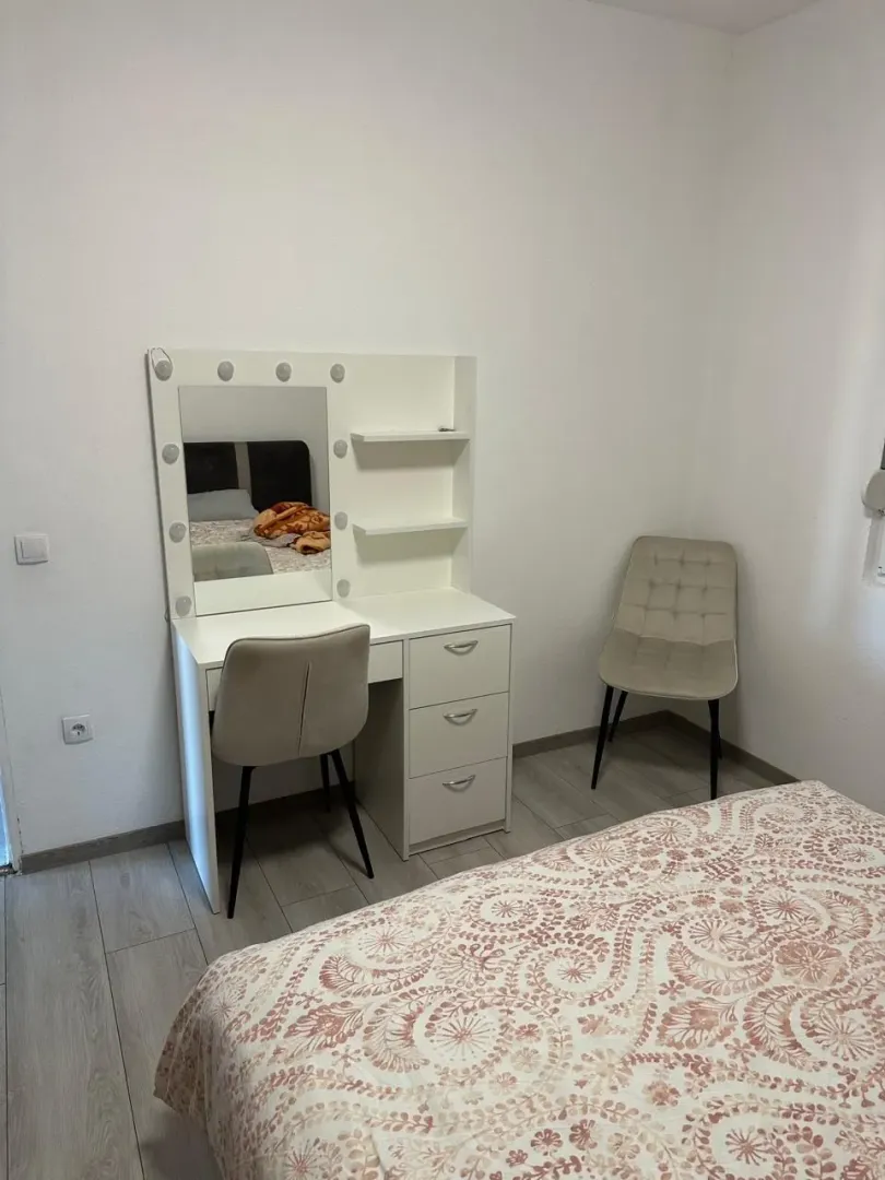Furnished bedroom with a bed, desk, and chairs.