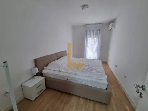 Svjetla i uredna spavaća soba sa bračnim krevetom i noćnim stočićem. - image 3