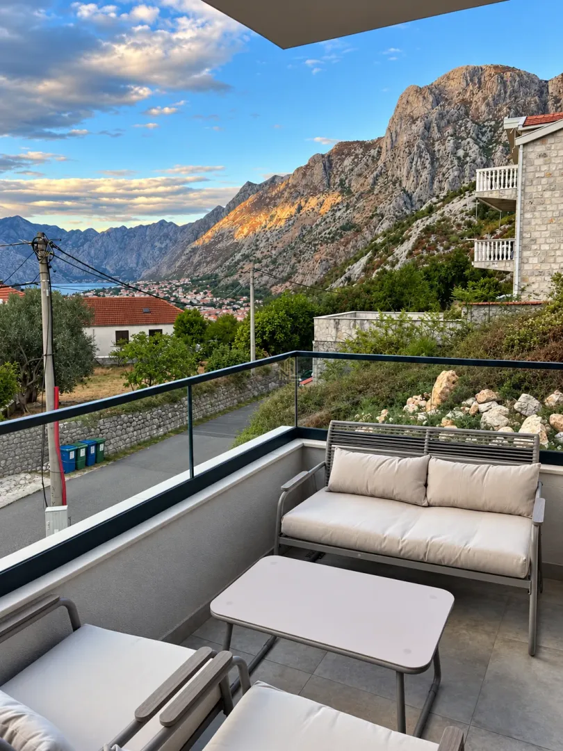 Furnished balcony with seating set and a view of the mountain and bay.
