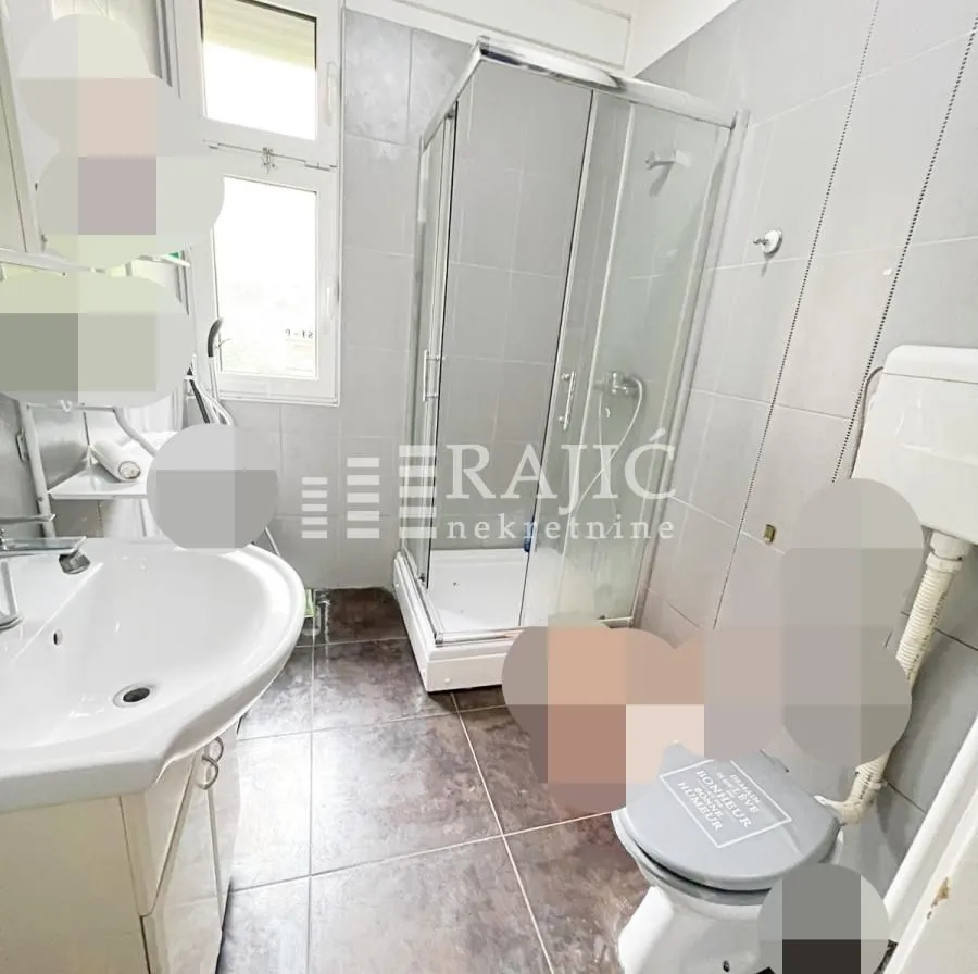 Small bathroom with a shower cabin, washbasin, and toilet.