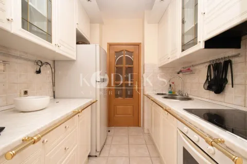 Kitchen equipped with white cabinets, built-in appliances, and a refrigerator. - image 3