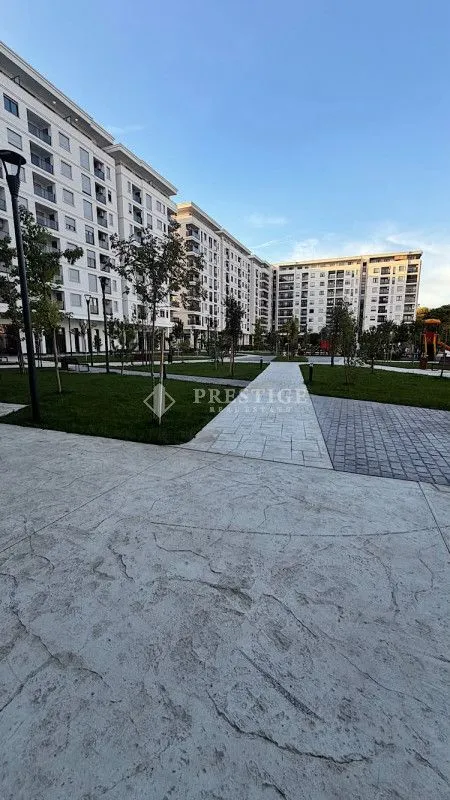 View of the courtyard and residential building facade with landscaped greenery.