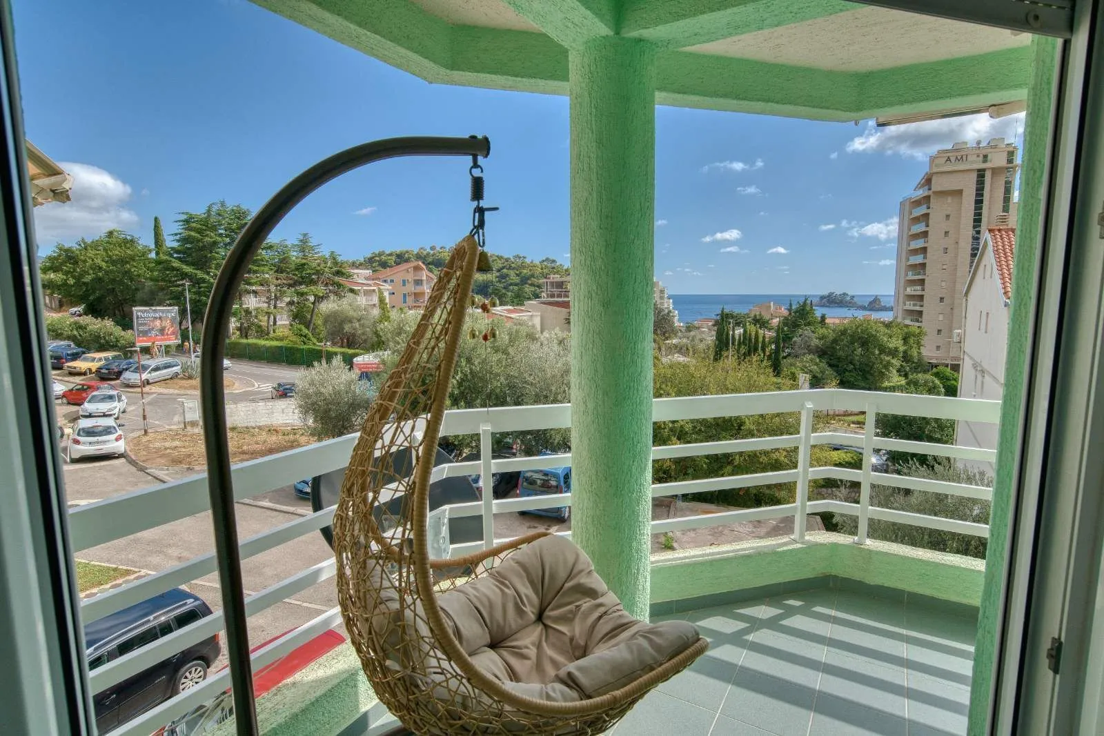 Covered terrace with a hanging chair and views of the sea and surroundings.