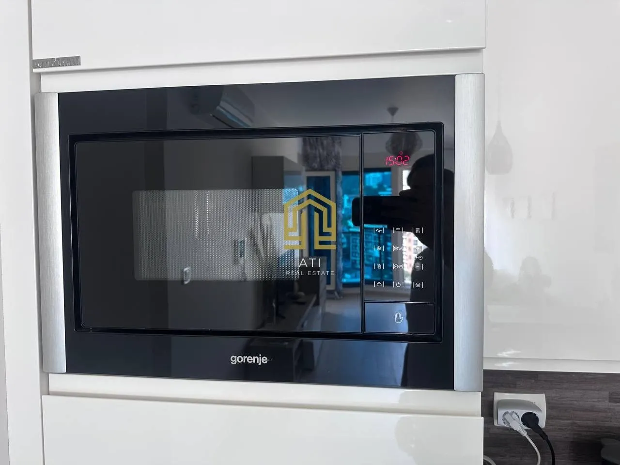 Built-in kitchen oven with white cabinetry.