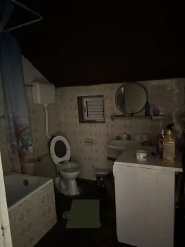 Kupatilo sa kadom, toaletom i veš mašinom pod slabim osvjetljenjem. - image 23