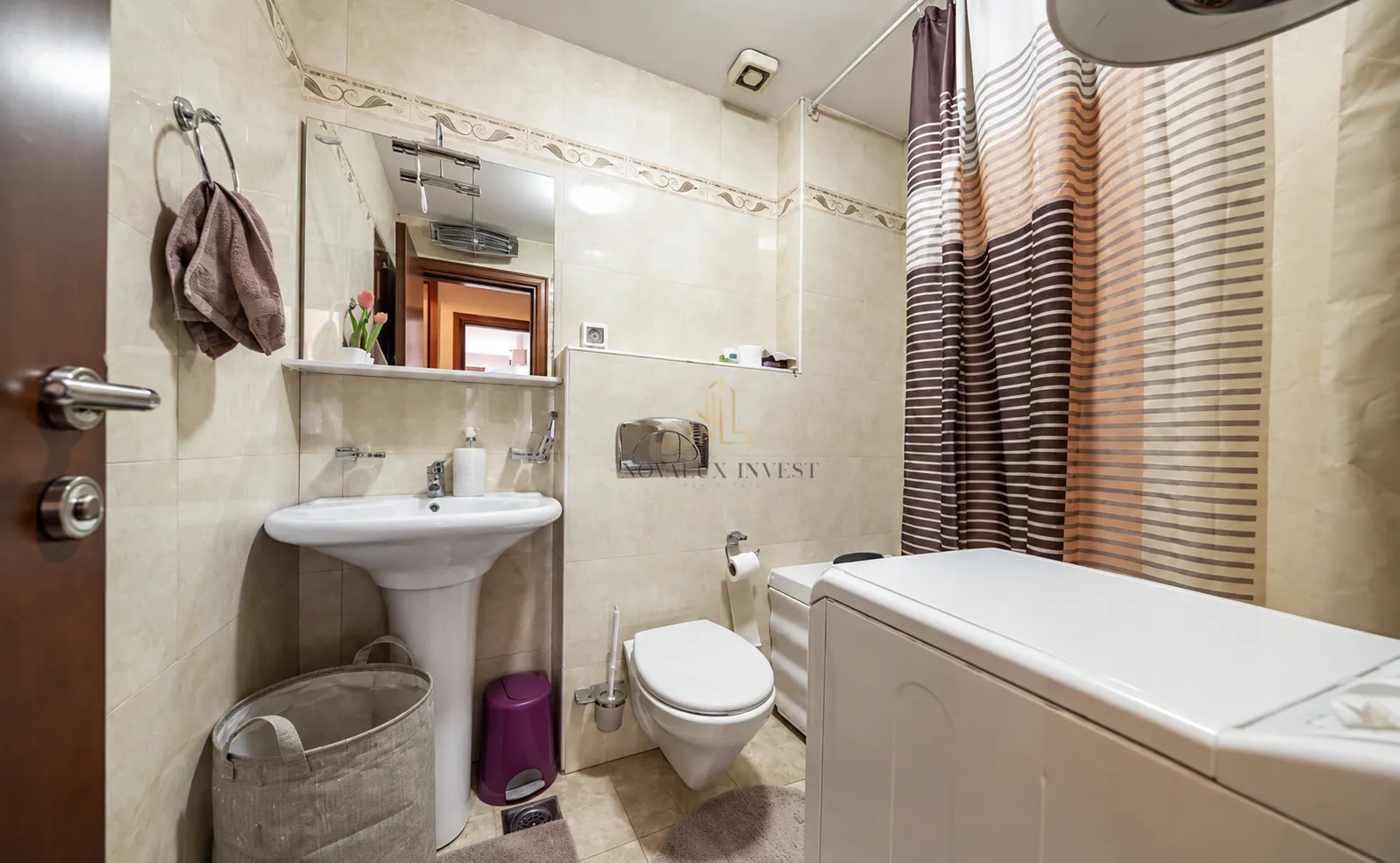 Bathroom equipped with a sink, toilet, shower, and washing machine.