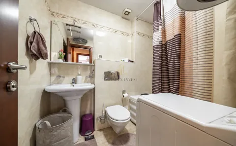 Bathroom equipped with a sink, toilet, shower, and washing machine. - image 9