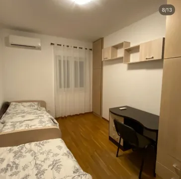 Furnished bedroom with two beds, a desk, and a wardrobe. - image 8