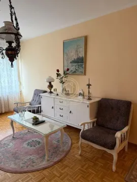Dnevna soba sa garniturom za sedenje, komodom i dekorativnim elementima. - image 4
