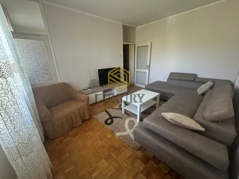 Living room with a sectional sofa, armchair, and TV unit. - image 2