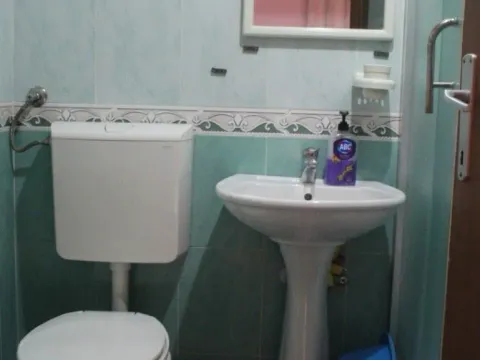 Small bathroom with a sink, toilet, and mirror. - image 2