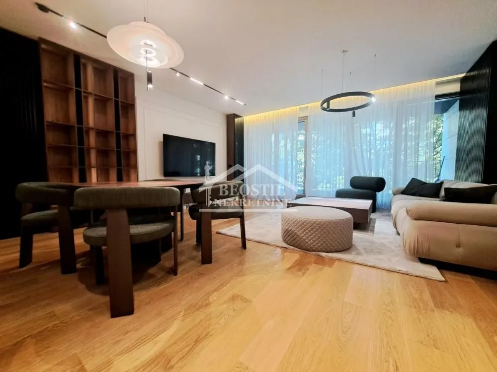 Spacious living room with a dining area, modern furniture, and wooden flooring.