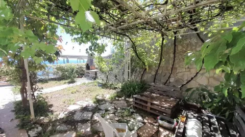 Yard with a covered terrace, barbecue, and sea view. - image 17