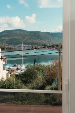 Pogled na zaliv i planine kroz prozor. - image 3