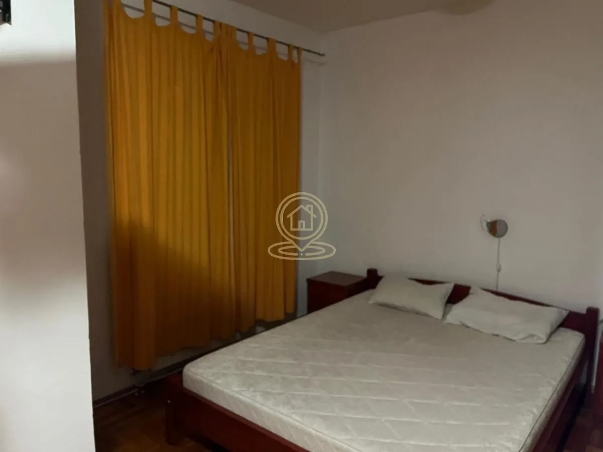 Bedroom with a double bed and yellow curtains.