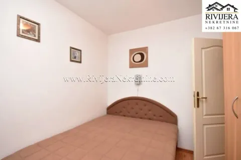 Manja spavaća soba sa bračnim krevetom i slikama na zidu. - image 5