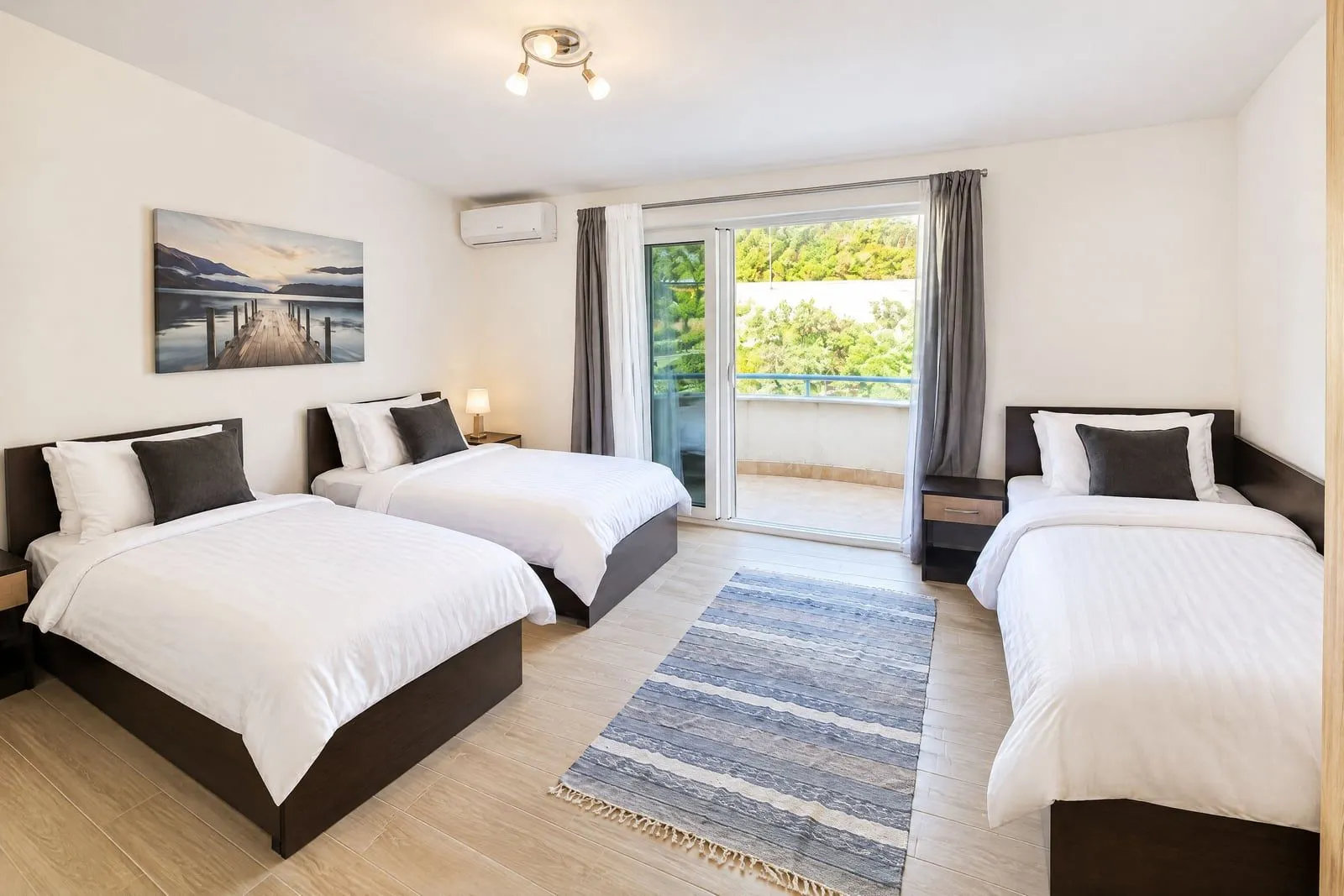 Spacious bedroom with three beds and access to the terrace.