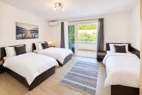 Spacious bedroom with three beds and access to the terrace. - image 12