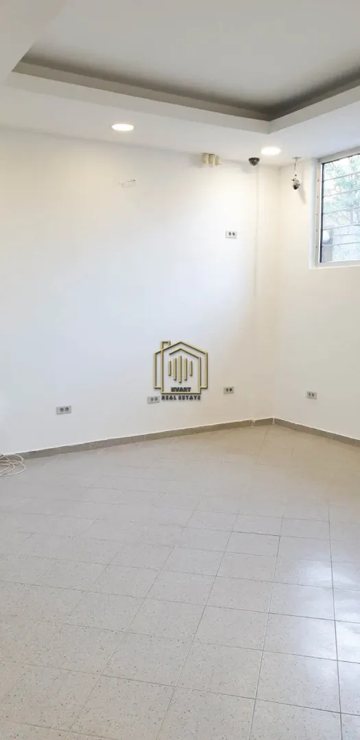 Empty bright room with tiled flooring and white walls.
