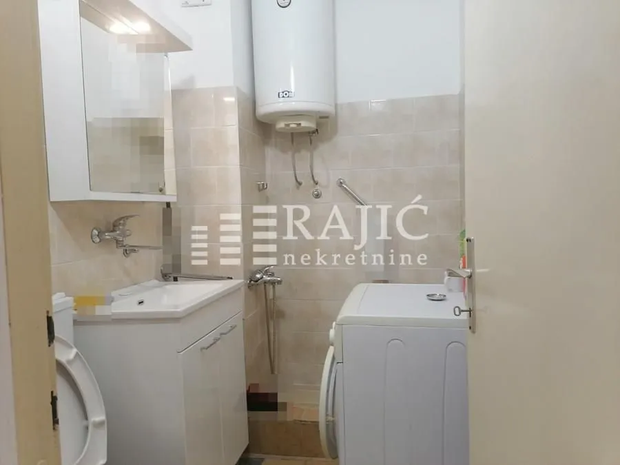 Smaller bathroom with sanitary fixtures and a washing machine.