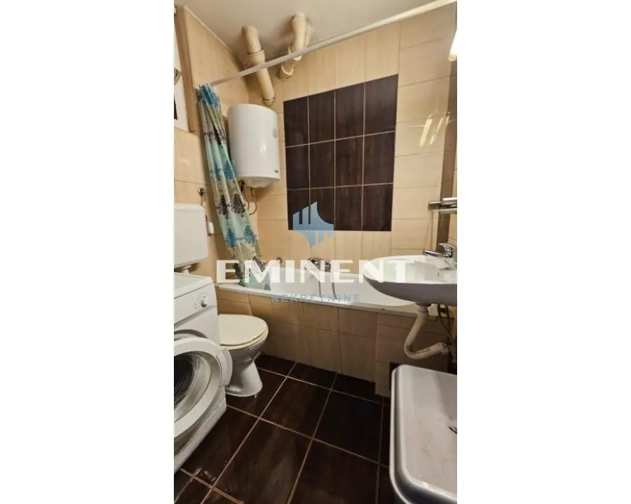 Manje kupatilo sa kadom, wc šoljom, umivaonikom i veš mašinom.
