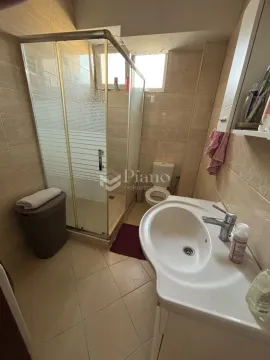 Bathroom equipped with a sink, a shower cabin, and a toilet. - image 9