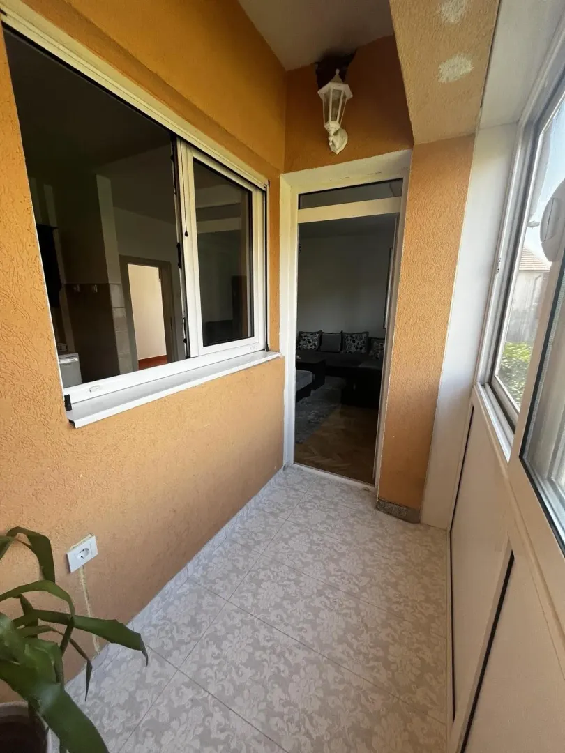 Zatvoreni balkon sa pločicama i pogledom na unutrašnjost.
