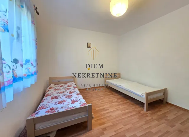 Dječja spavaća soba sa dva kreveta i laminatom.