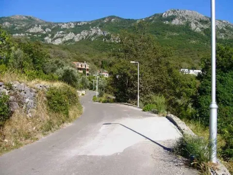 Asfaltni put koji vodi uzbrdo prema kućama u planinskom predjelu. - image 4