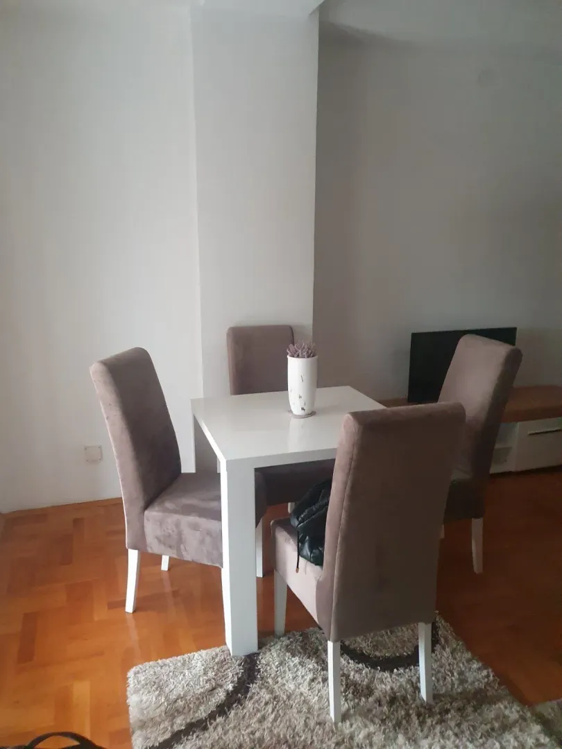 A dining table with four chairs in a living area.