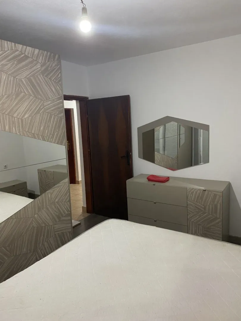 A bedroom featuring modern furniture and a mirror.
