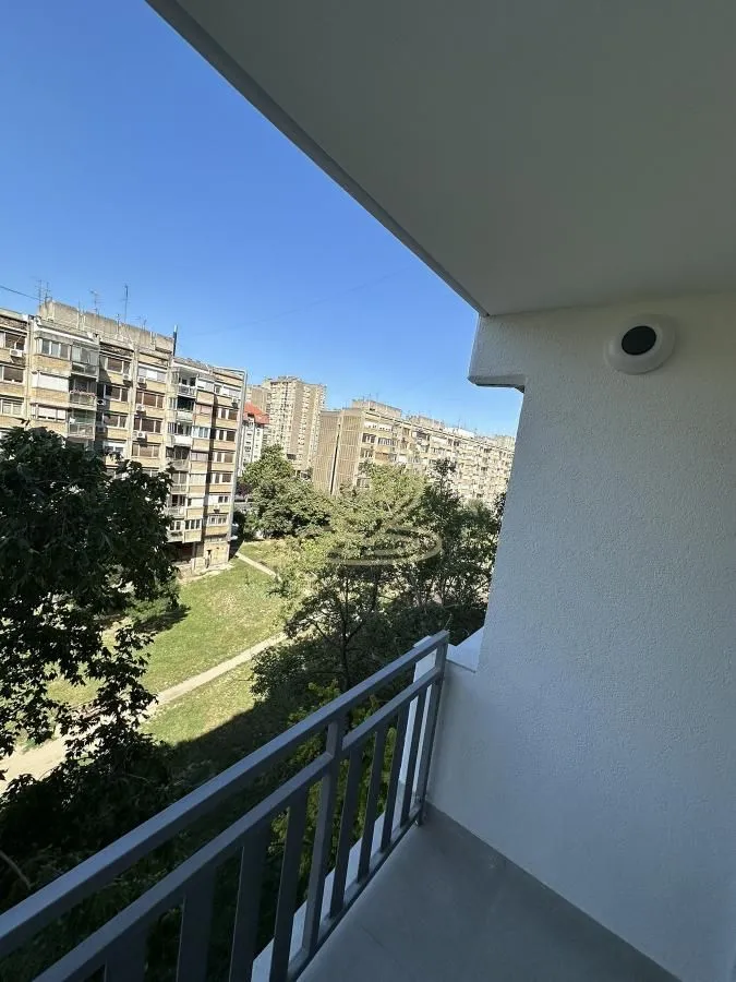 Pogled sa terase na okolne zgrade i zelenilo.