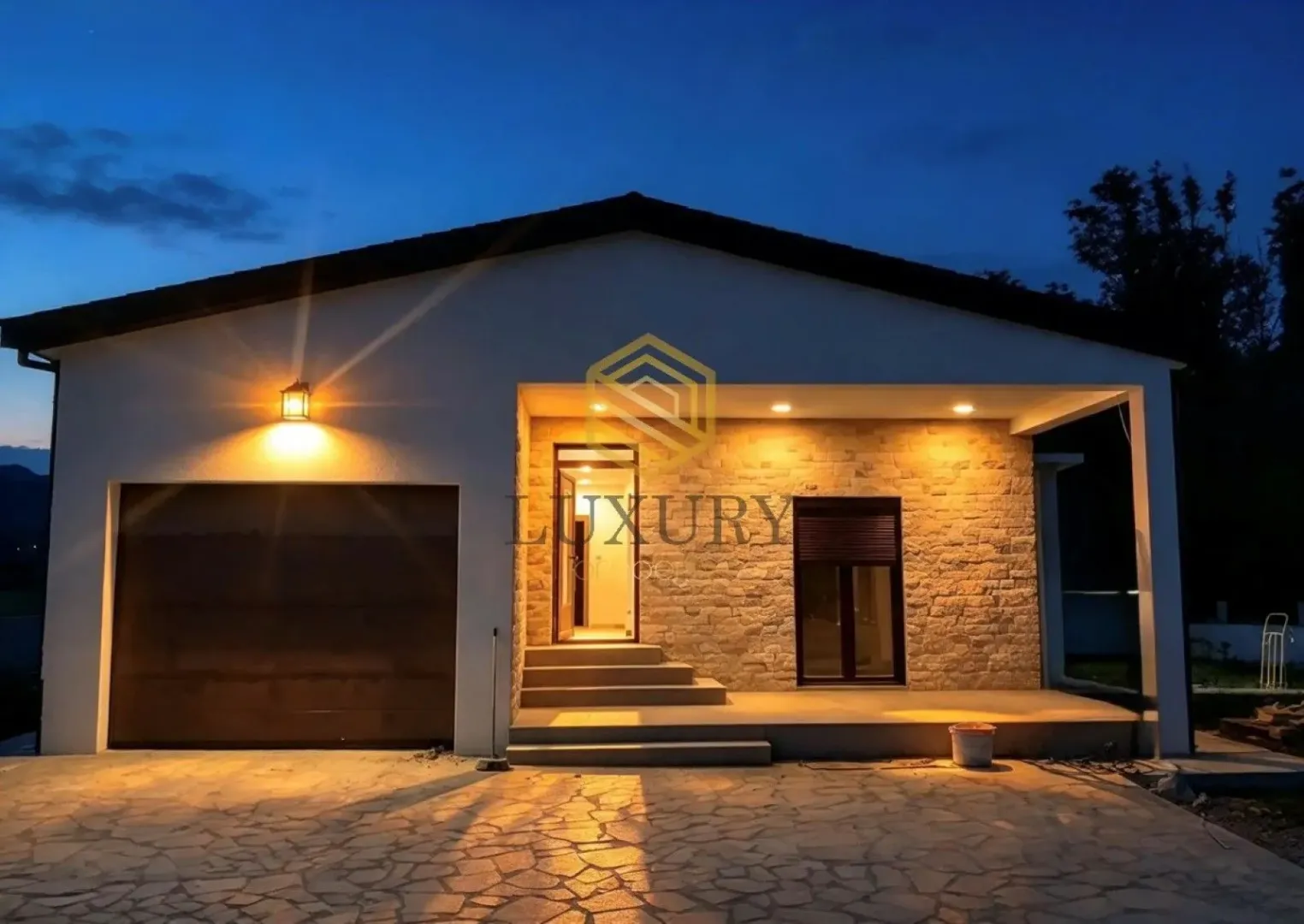 Exterior of a single-story house with illuminated facade at dusk.