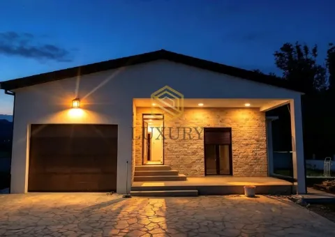 Exterior of a single-story house with illuminated facade at dusk. - image 18